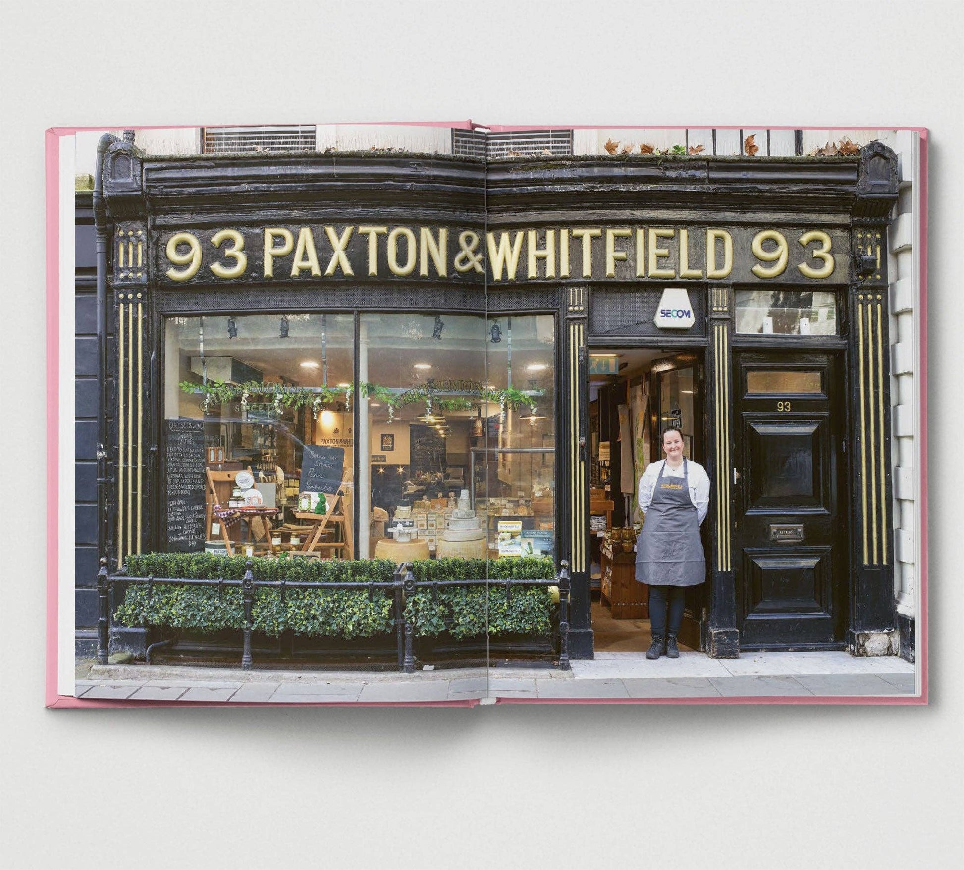 Storefront with '93 Paxton & Whitfield' signage, person standing in doorway.