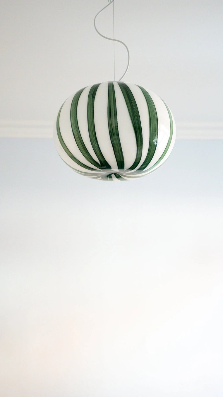 Green and white striped spherical lamp on a white background