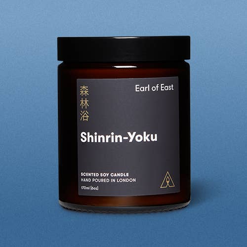 Scented soy candle jar labeled 'Shinrin-Yoku' by Earl of East on a blue background