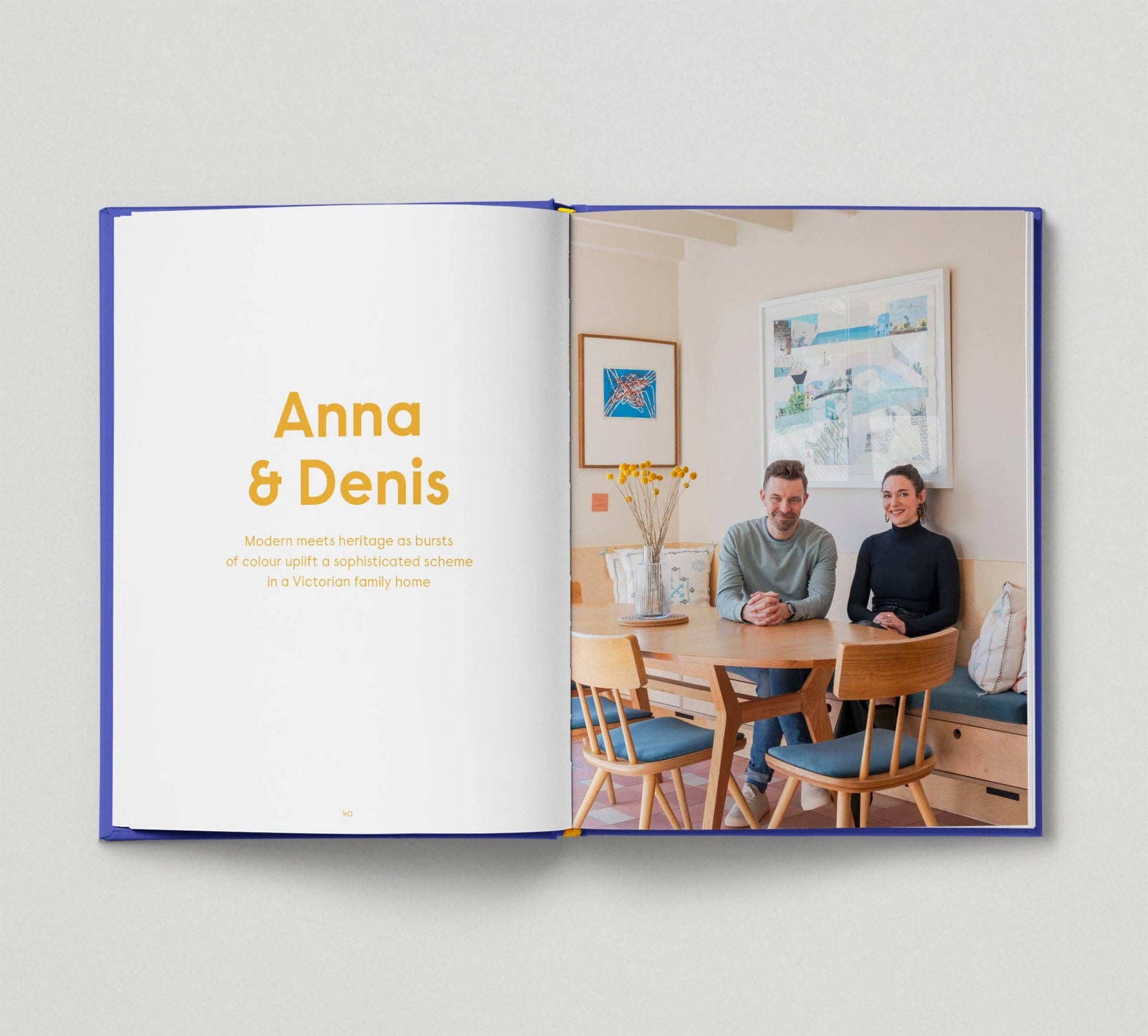 Open book showing a photo of two people sitting at a table with 'Anna & Denis' text.