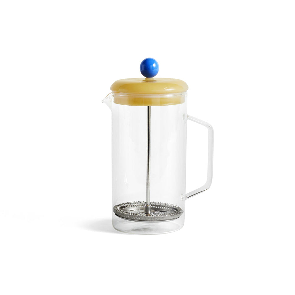 French press with clear glass body and yellow lid with blue plunger 