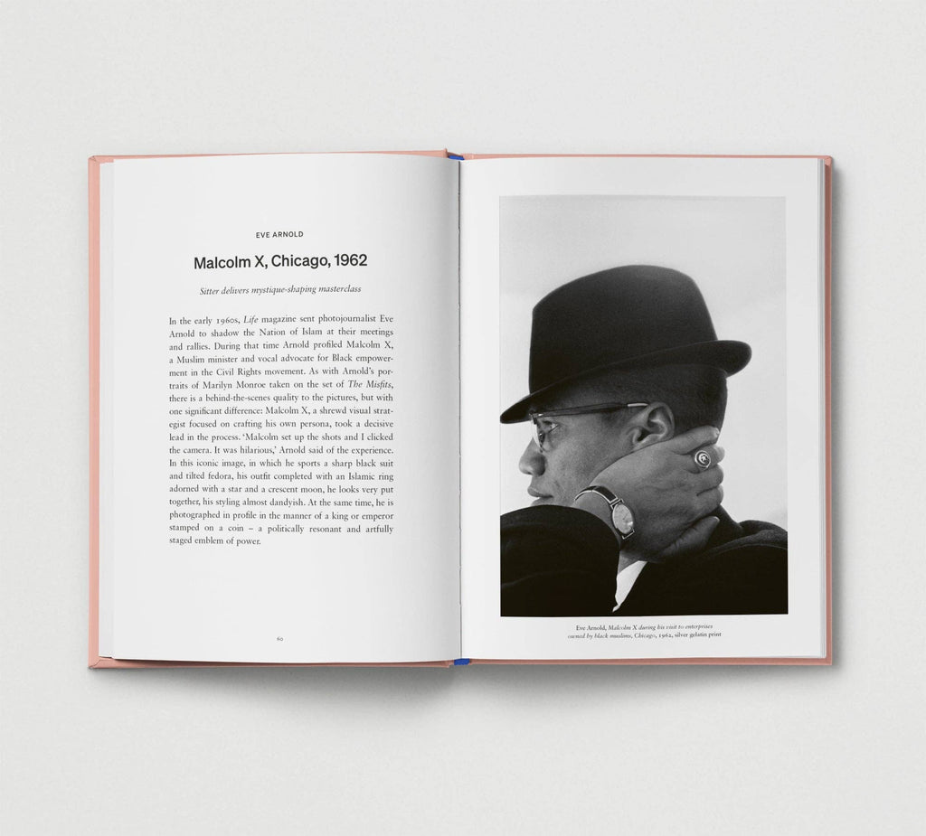 Open book showing a black and white photo of a man wearing a hat and glasses, with text on a light gray background.