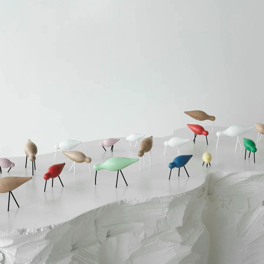 Collection of colorful miniature chairs on a white surface with a plain background
