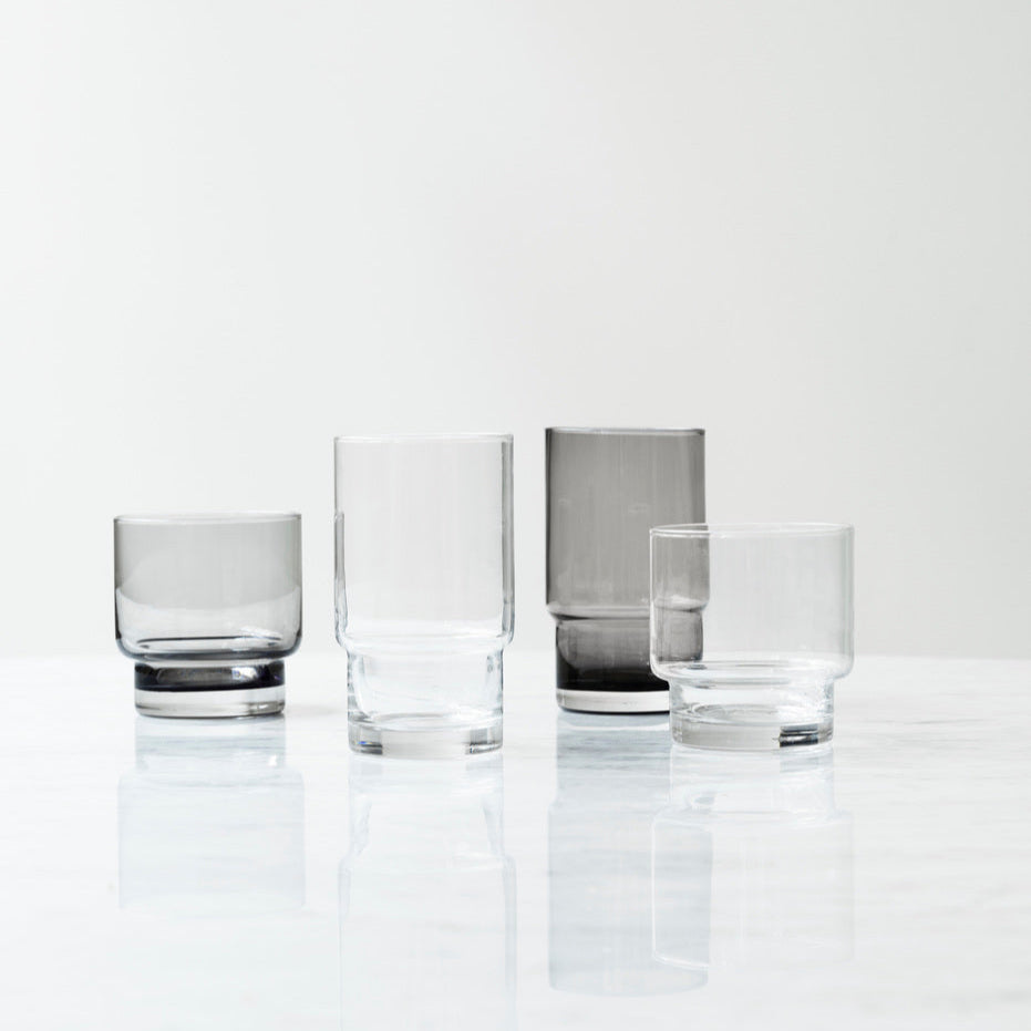 Set of four clear glass tumblers on a white background