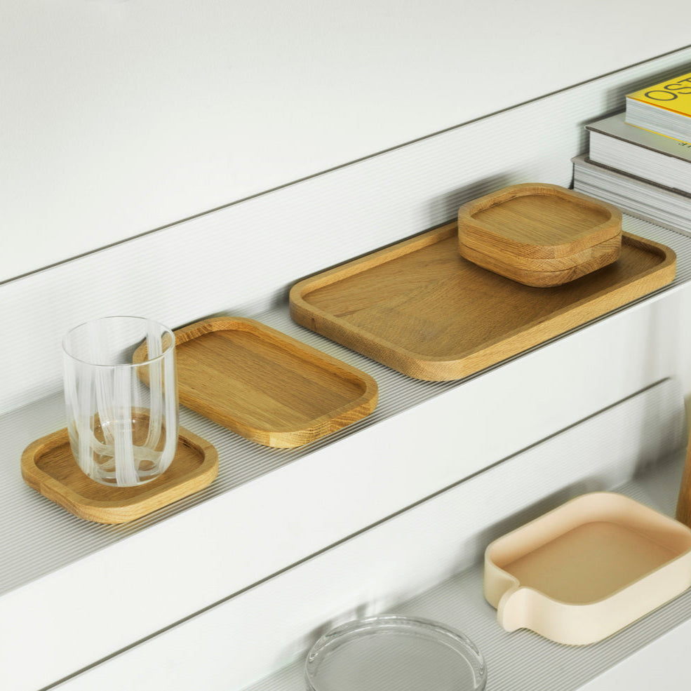 Set of wooden trays and coasters on a white surface