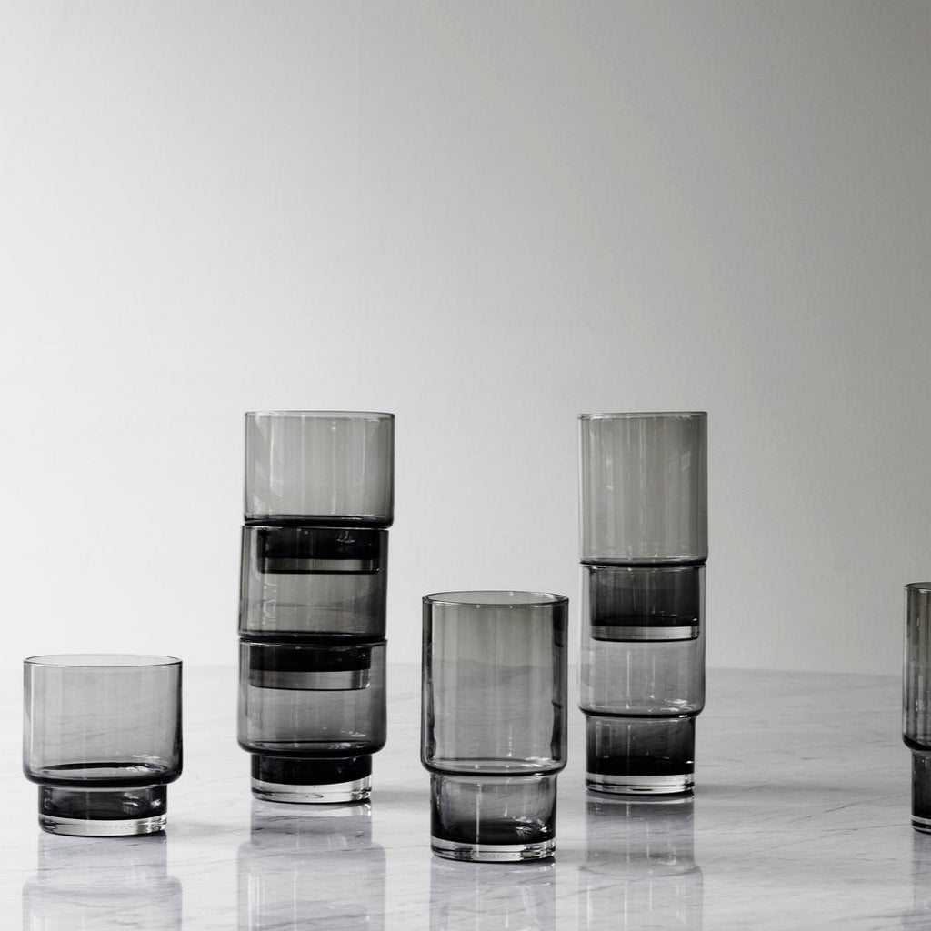 Set of smoked glass tumblers on a light gray background