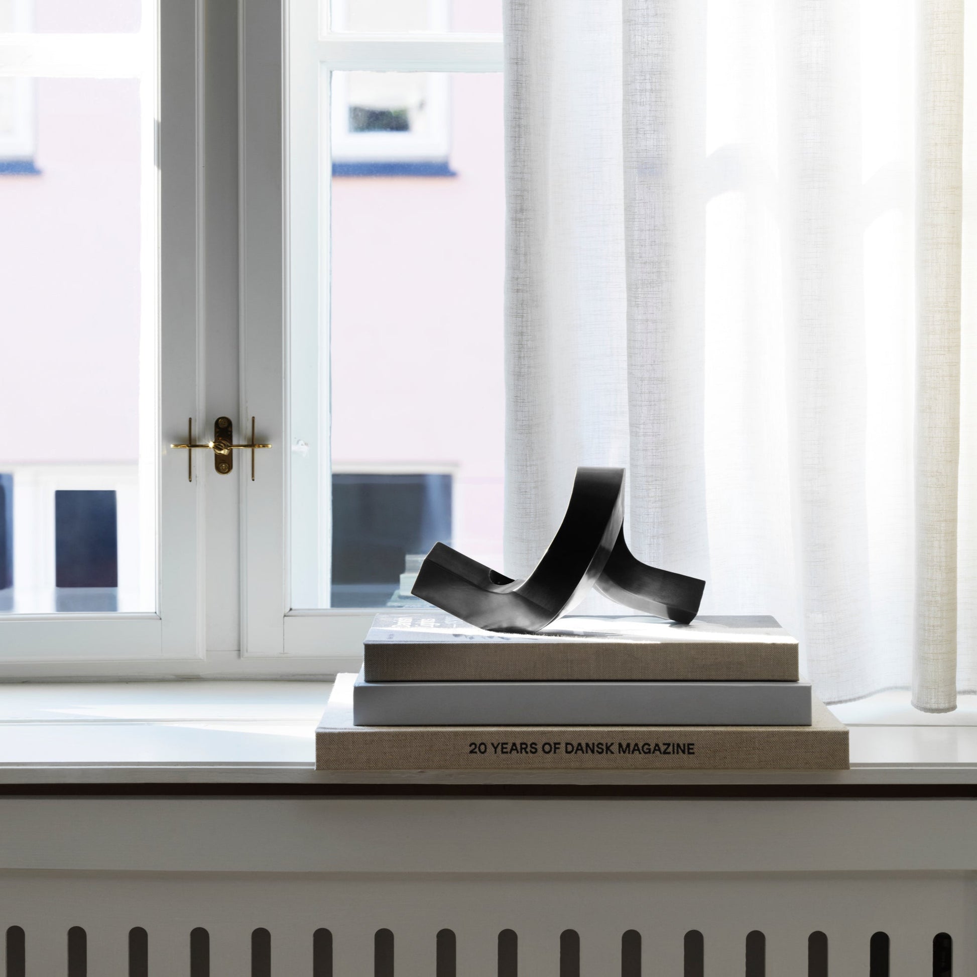 Decorative book with a sculpture on top in front of a window