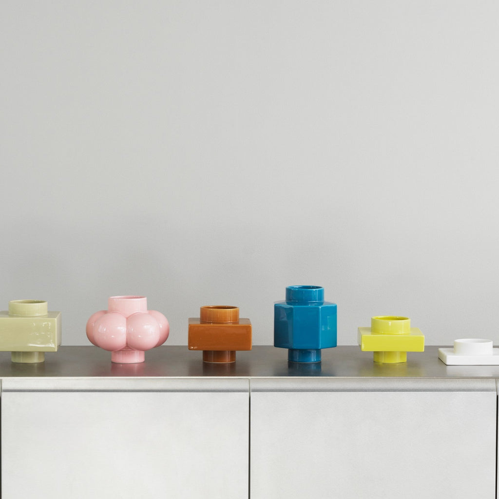 Colorful vases on a gray surface with a light gray background