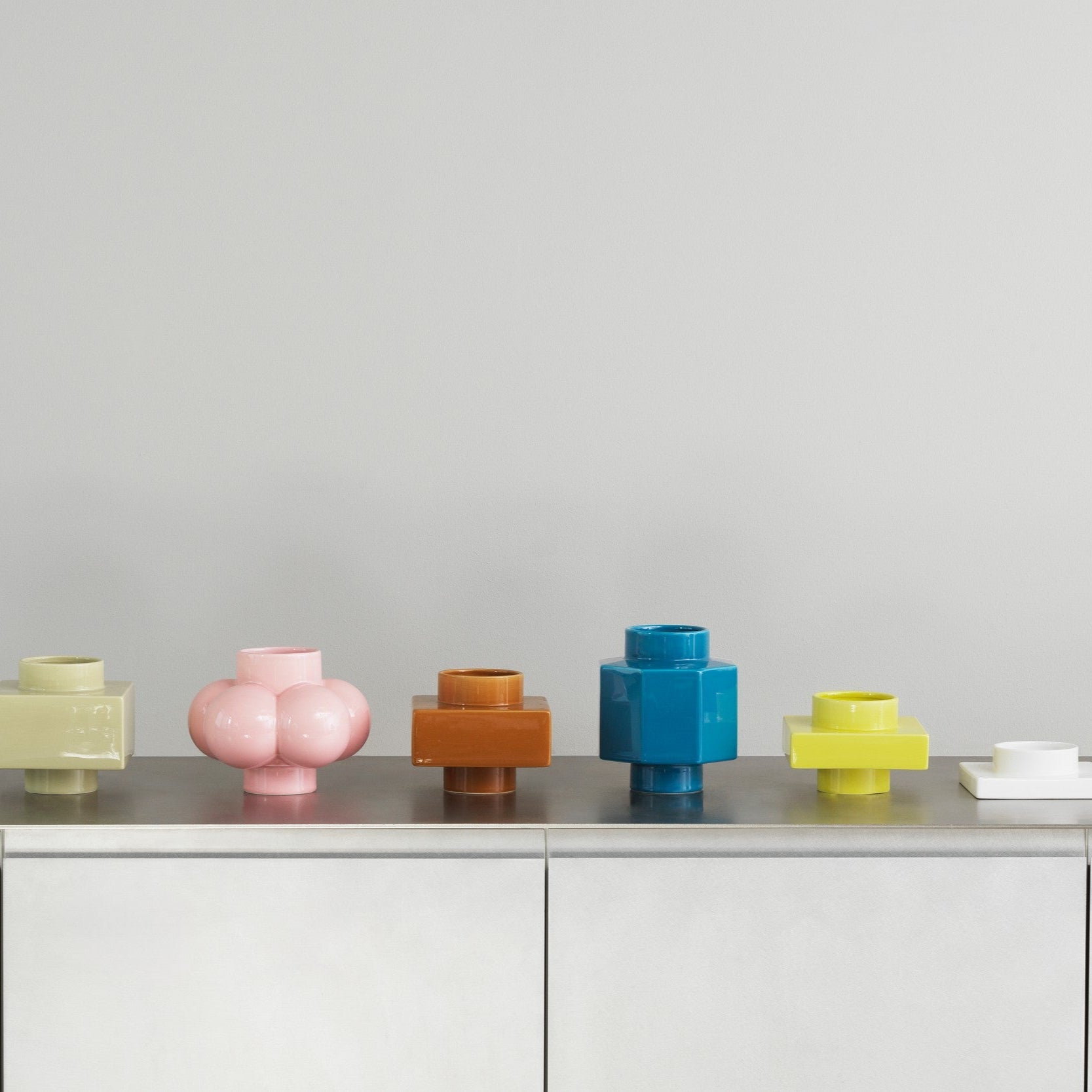 Colorful vases on a gray surface with a light gray background