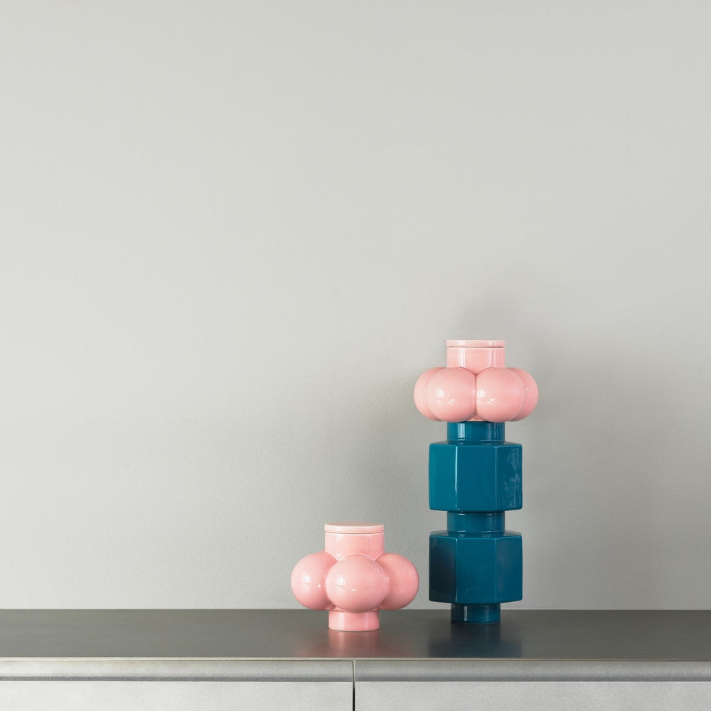 Two colorful vases on a metallic surface with a plain background