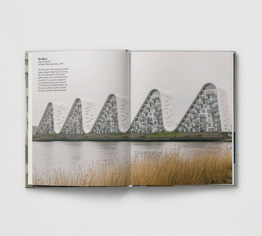 Open book showing a photograph of a modern architectural structure by a body of water.