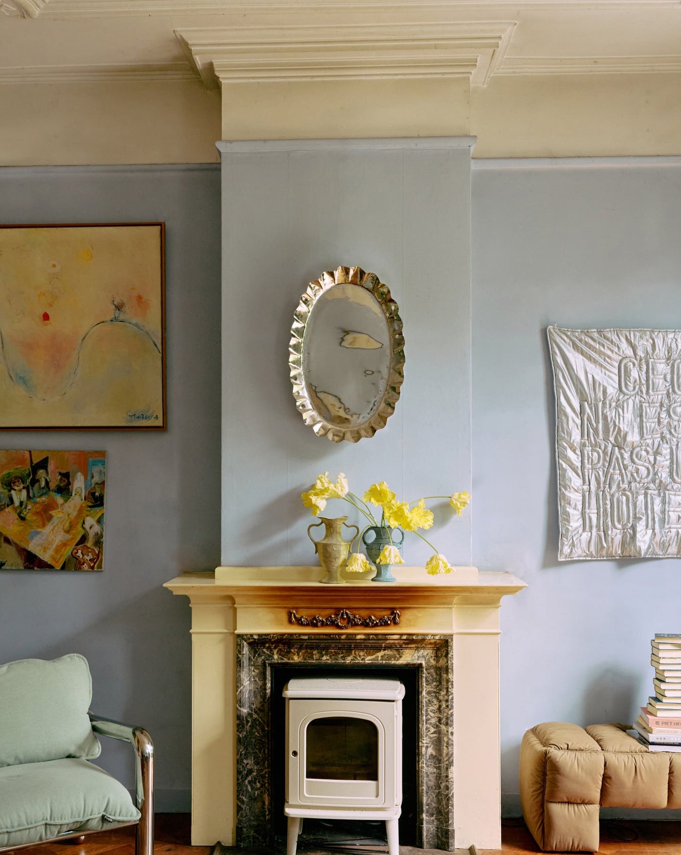 Living room with fireplace, artwork on the wall, and a chair.