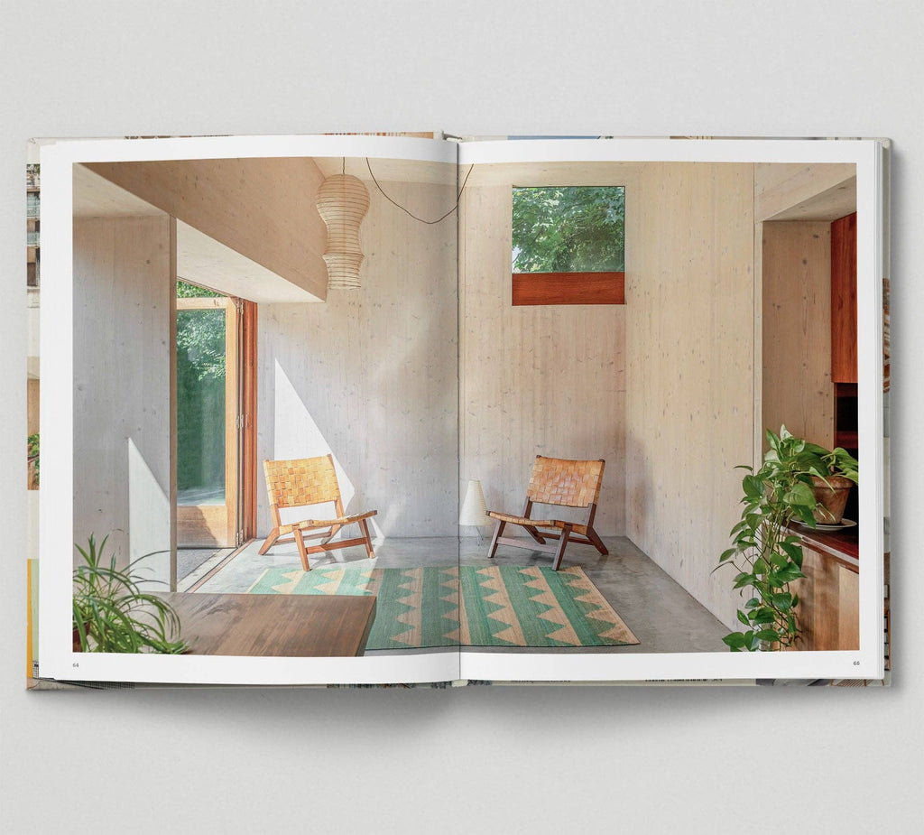 Open book showing a modern interior design with wooden chairs and plants.