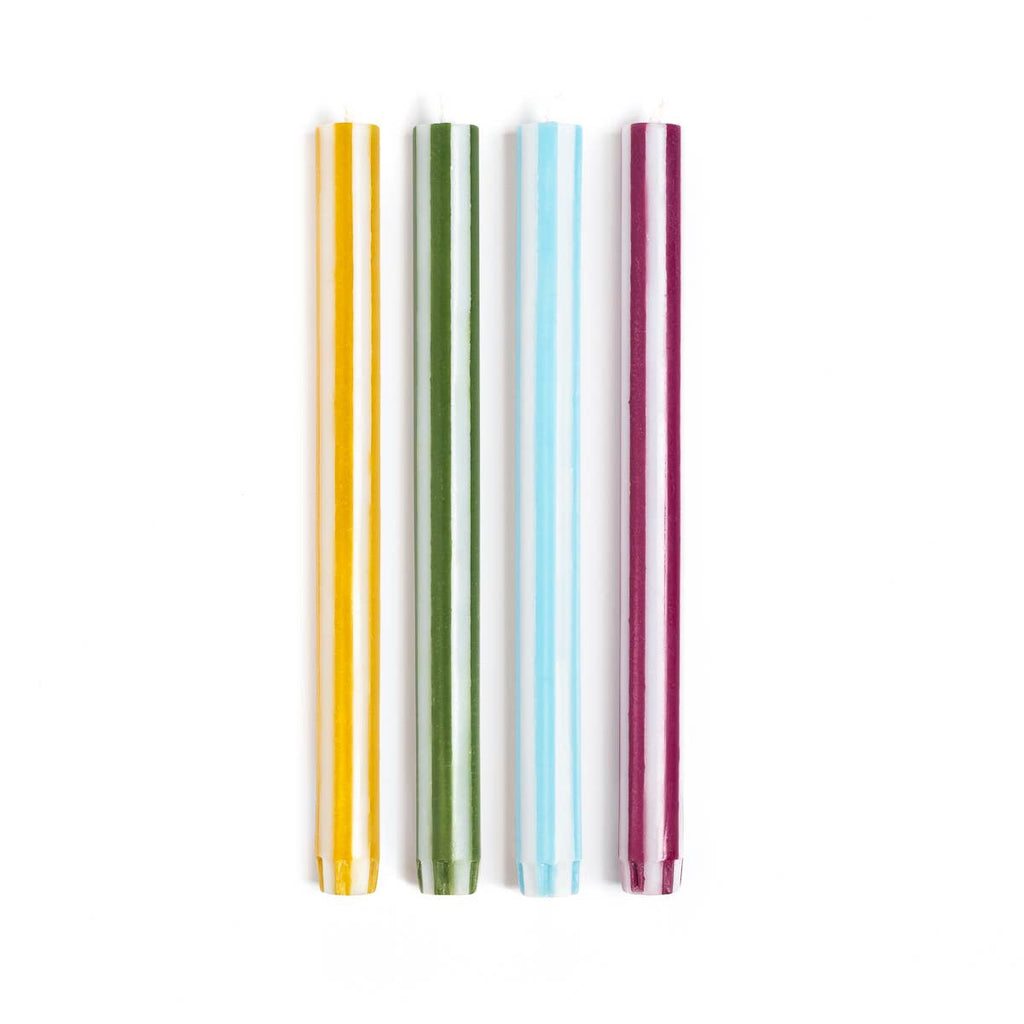 Multi coloured striped candles on a white background