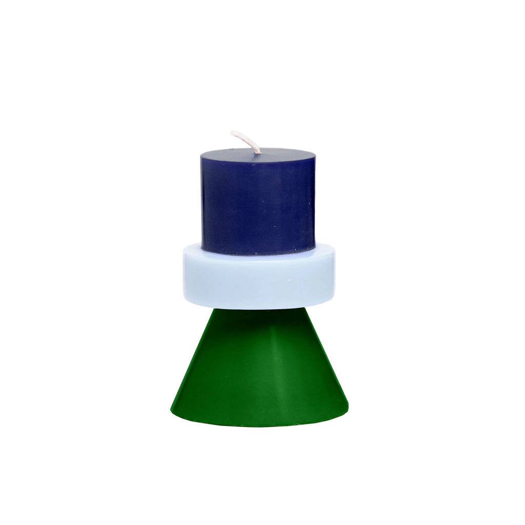 Navy blue candle on a white base with a green cone-shaped holder on a light gray background