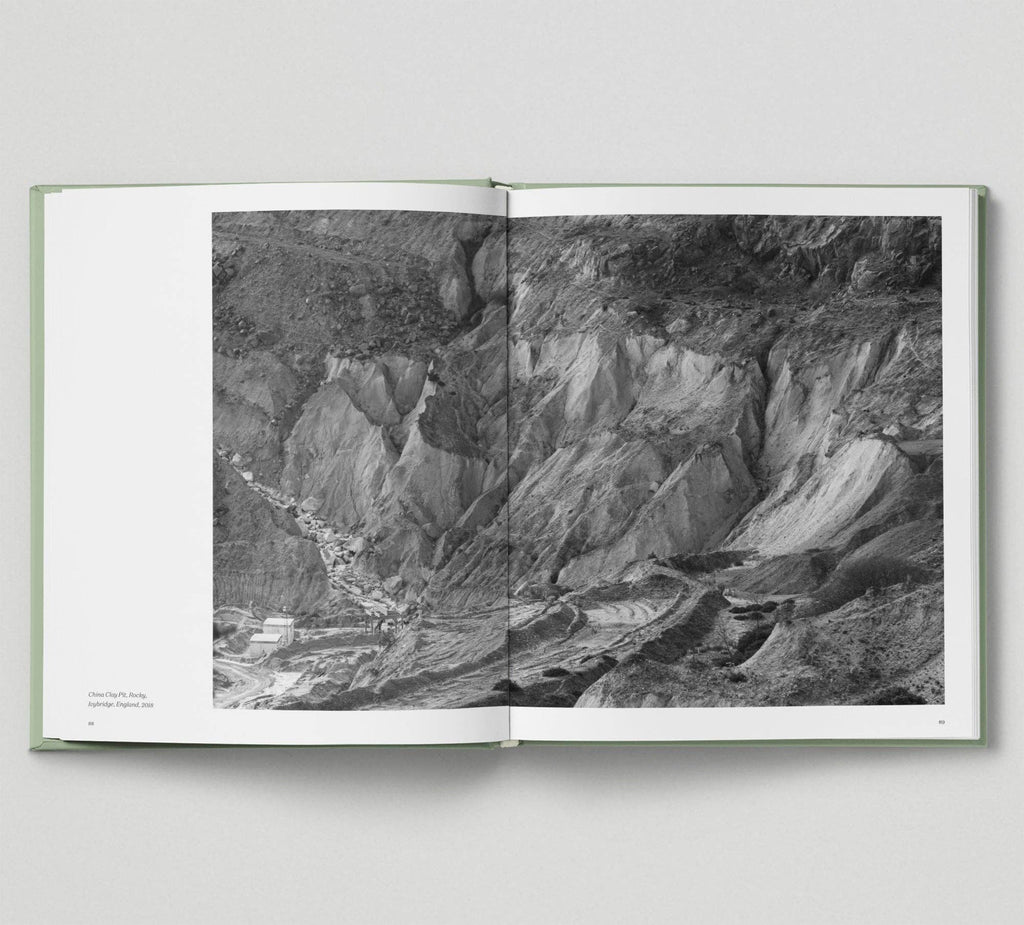 Open book displaying a black and white photograph of a mountainous landscape.