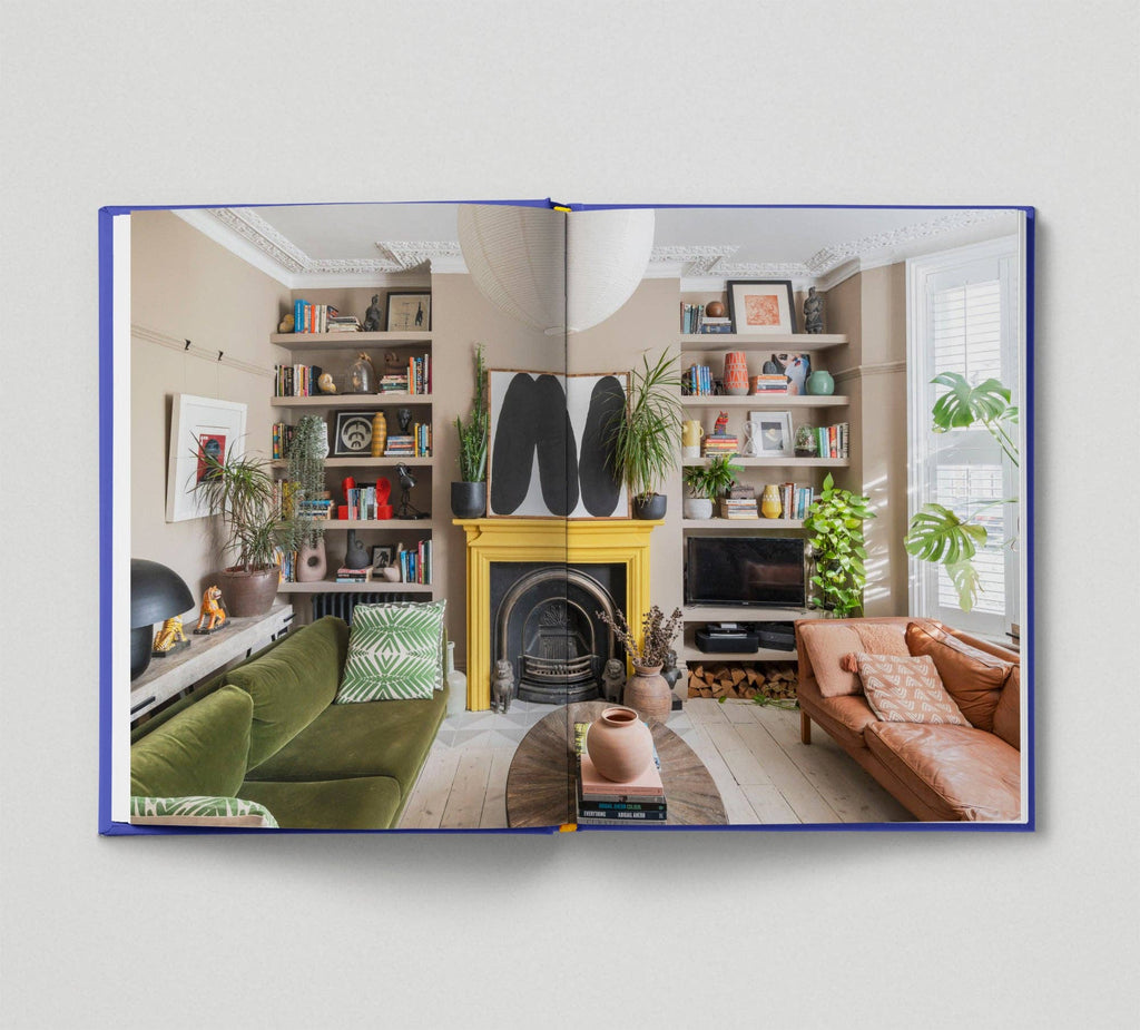 Open book showing a living room with a yellow fireplace, green sofa, and brown armchair.