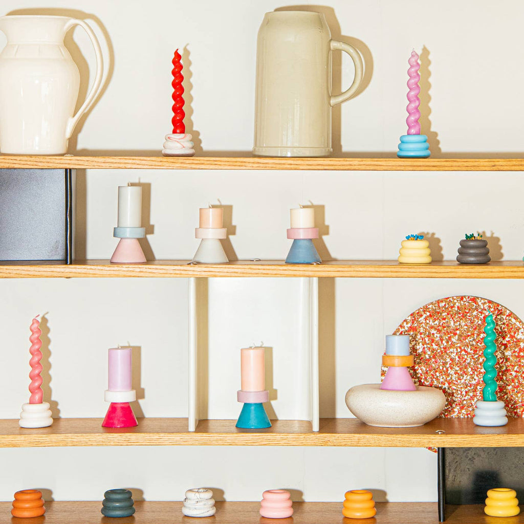 Wooden shelves with decorative items including candles and ceramic pieces against a white wall.