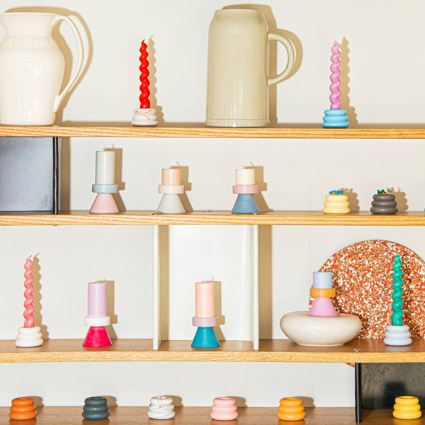 Wooden shelves with decorative items including candles and ceramic pieces against a white wall.