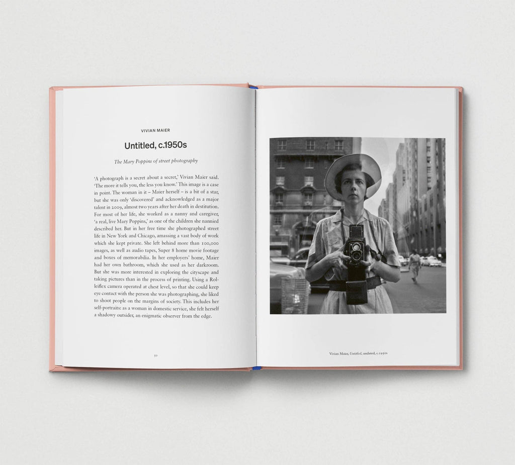 Open book with a black and white photo of a person holding a camera on a city street.