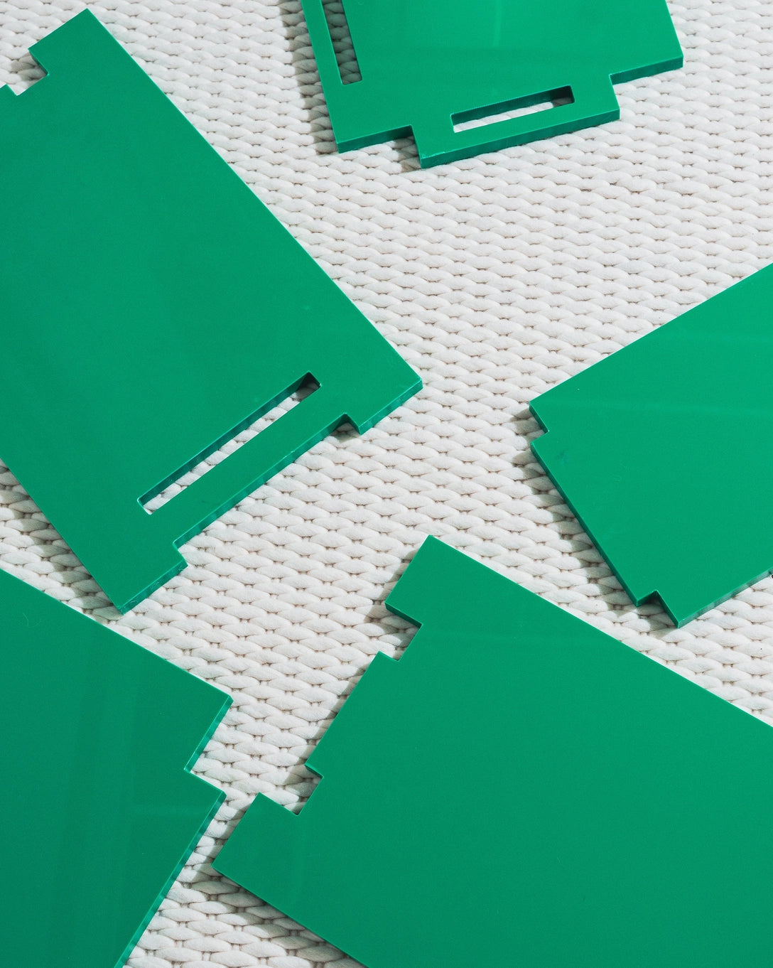 Green plastic furniture pieces on a textured white surface