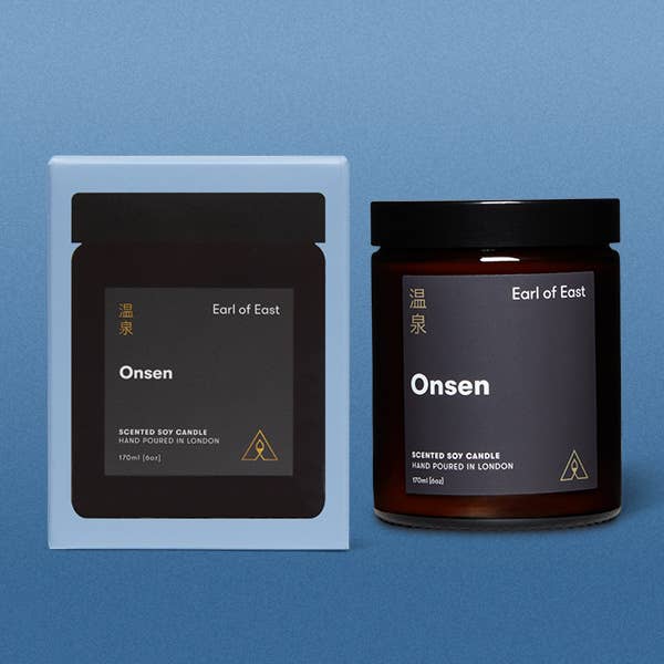 Earl of East Onsen scented soy candle packaging on a blue background
