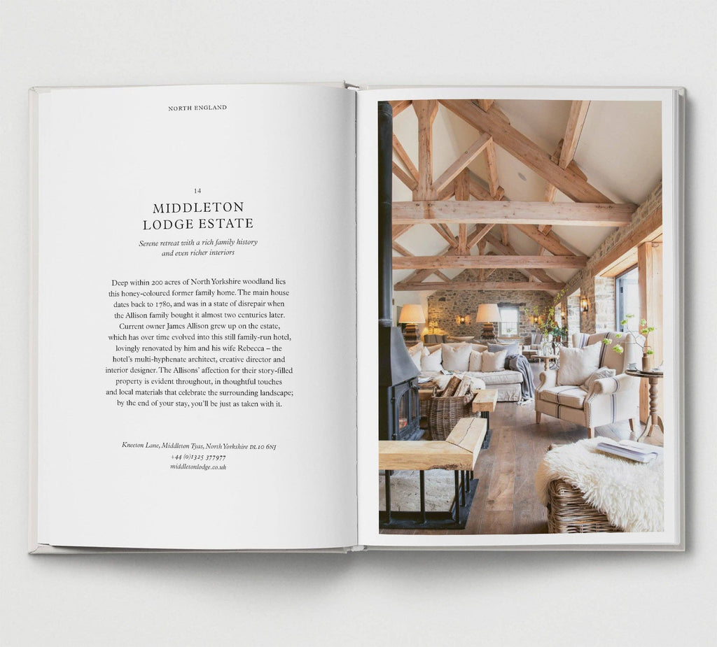 Open book showing a photograph of a luxurious interior design with wooden beams and modern furniture.