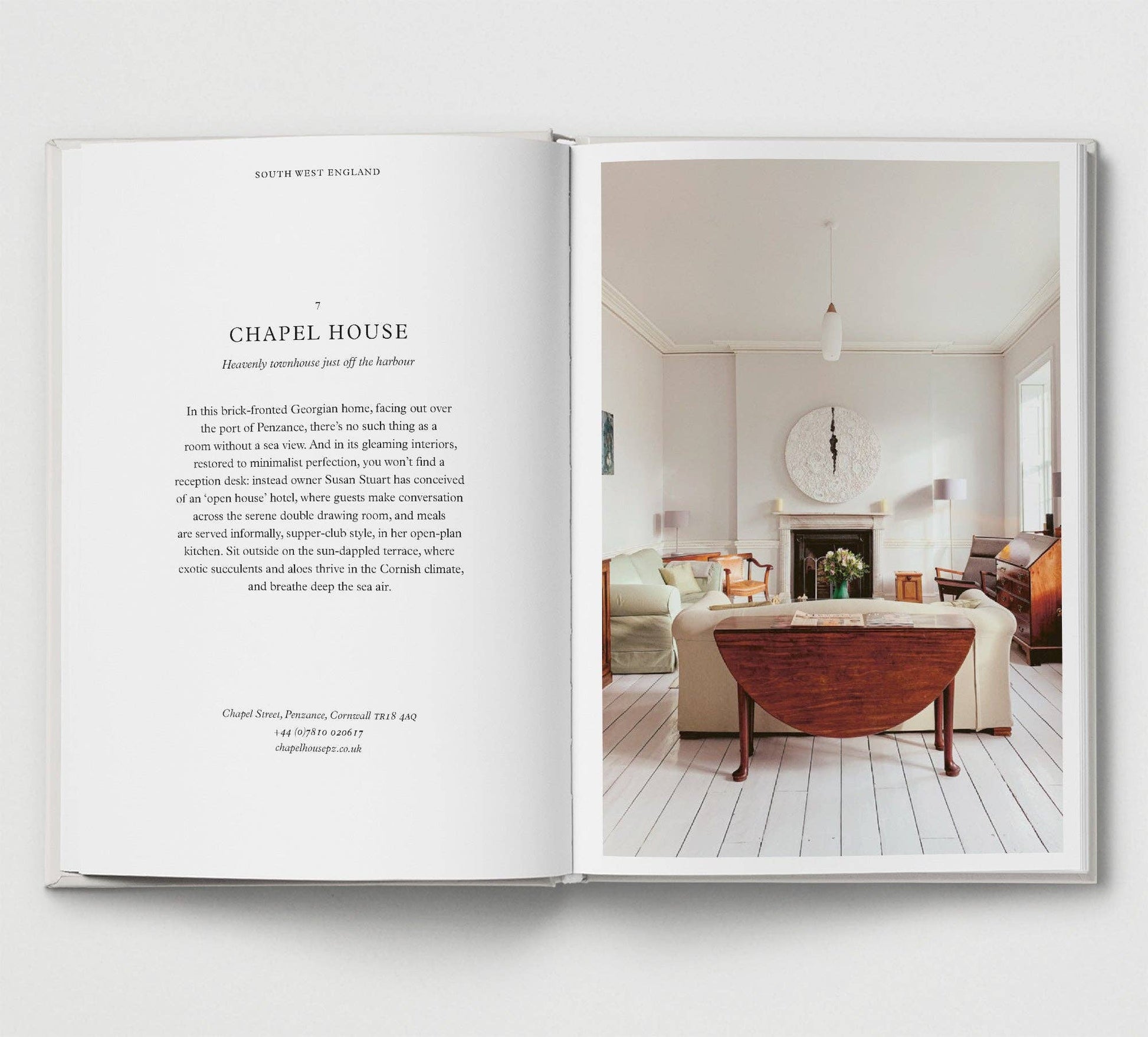 Open book showing a living room interior with a fireplace and furniture.