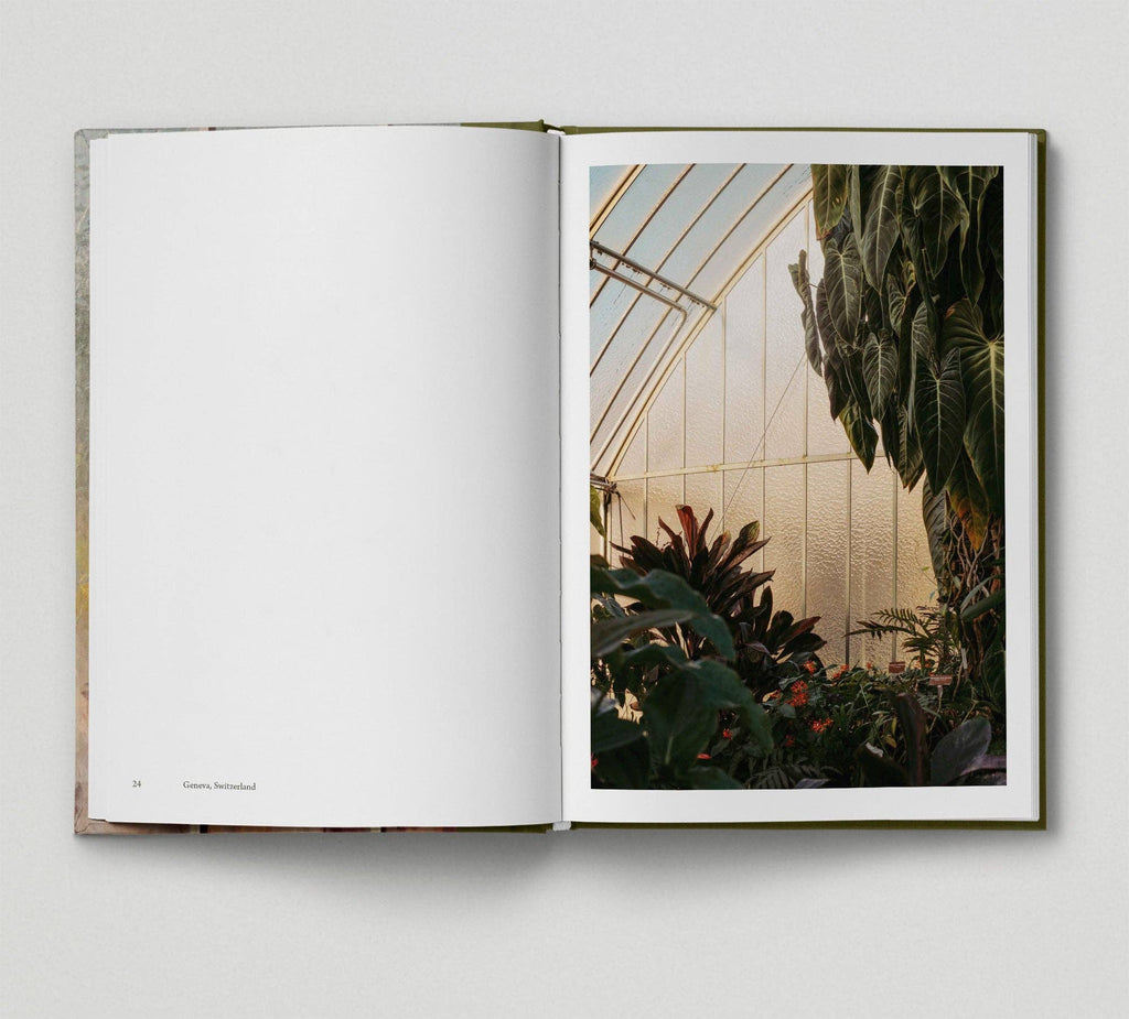 Open book showing a photograph of a greenhouse interior with plants.