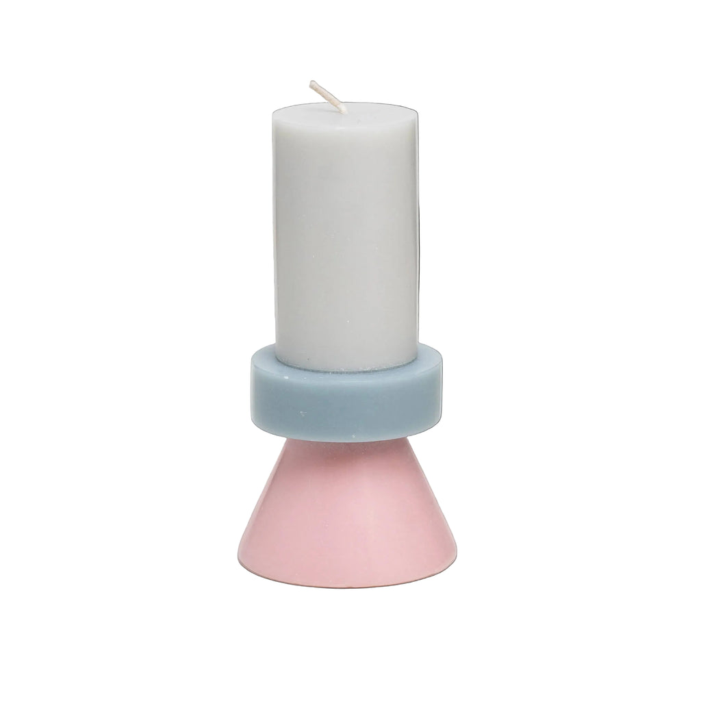 Candle in a pink and blue holder on a white background