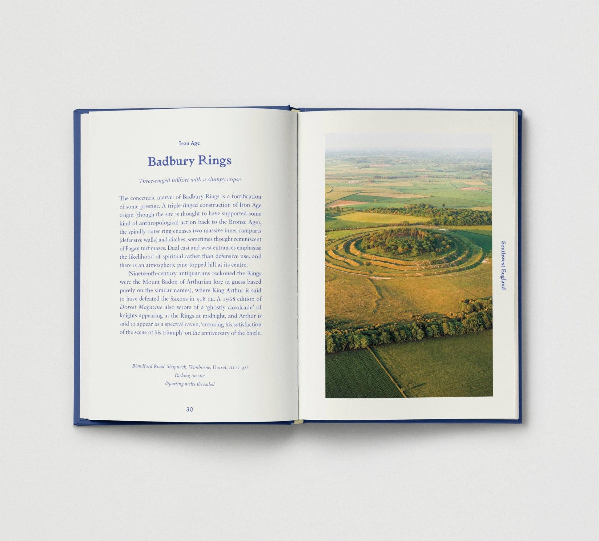 Open book showing an image of Badbury Rings with text on a white background