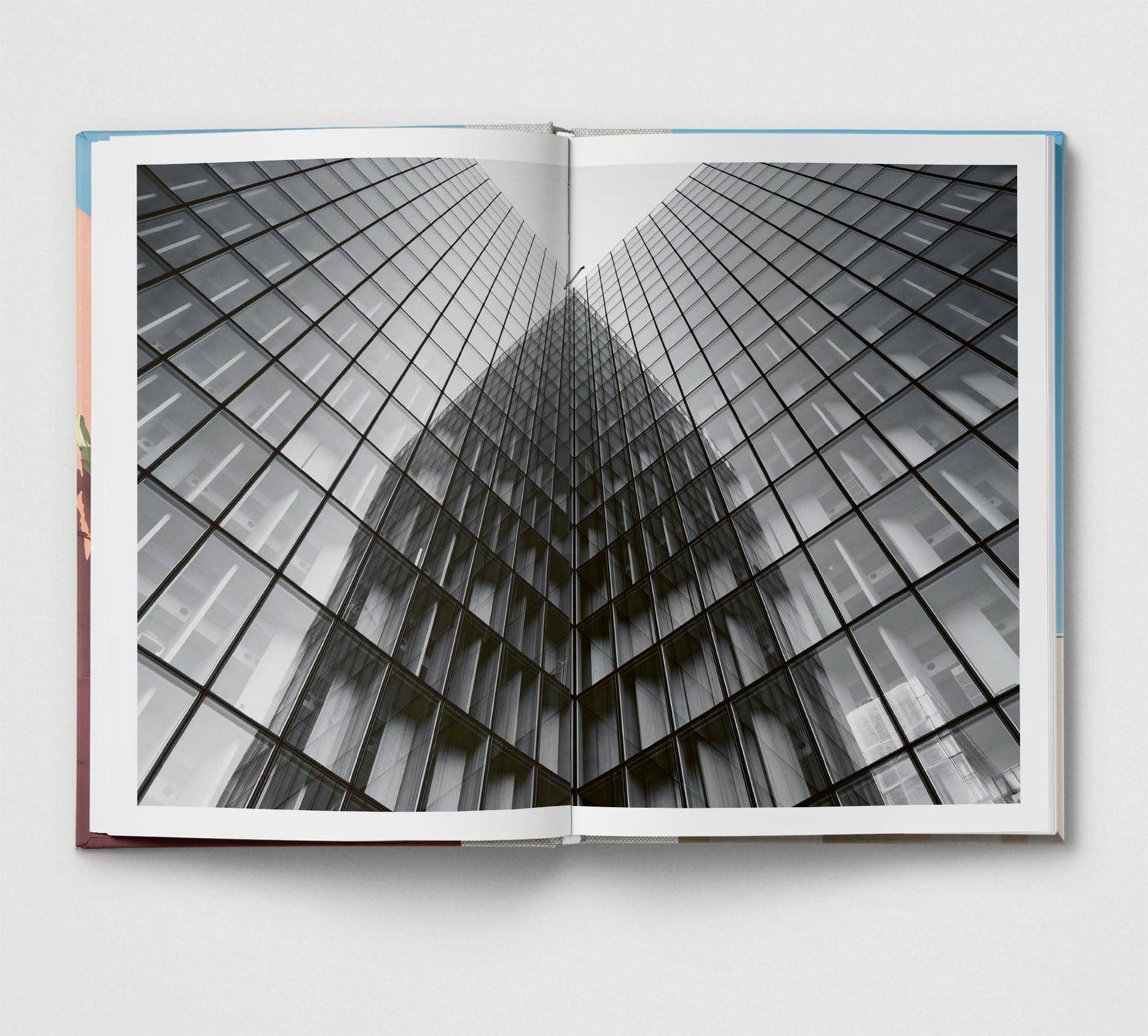 Open book showing a black and white photo of a glass building