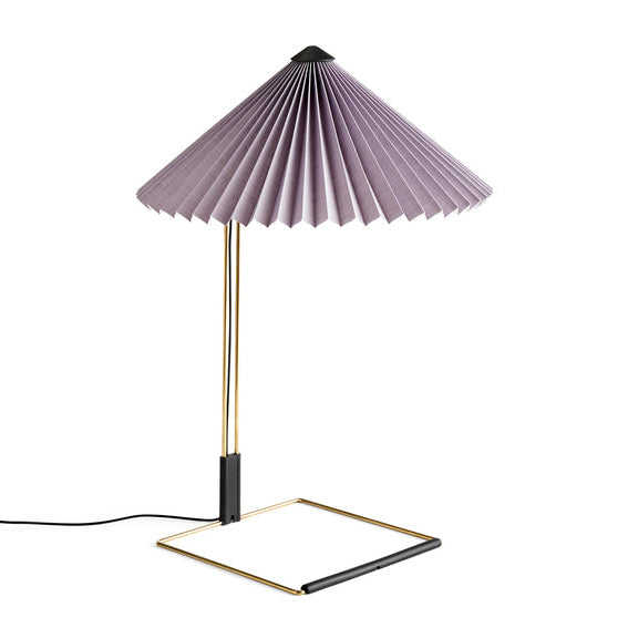 Table lamp with pleated purple shade and gold base on a white background