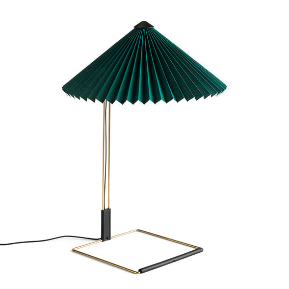 Table lamp with green pleated shade and gold base on a white background