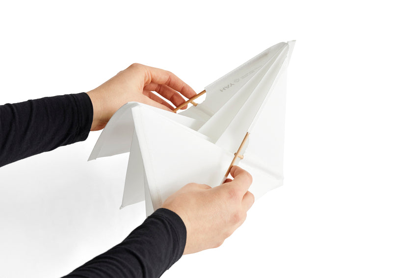 Person holding a white paper lamp n a white background