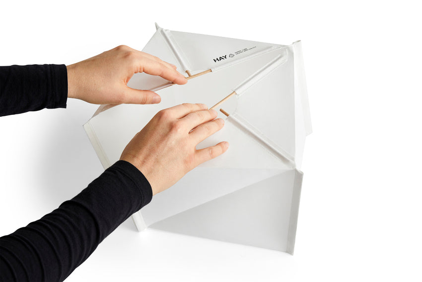 Person opening a white box with 'HAY' branding on a white background