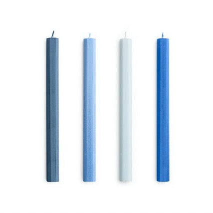 Four candles of different colors arranged in a row on a white background