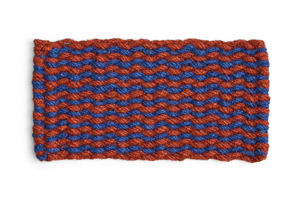 Door mat with woven pattern of red and blue yarn on a white background