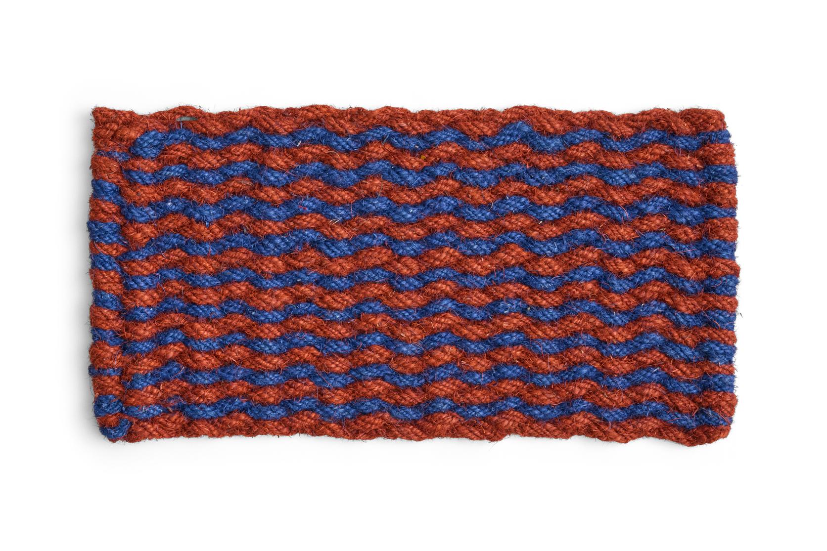 Door mat with woven pattern of red and blue yarn on a white background