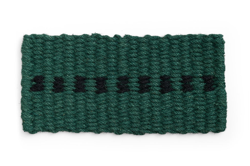 Green knitted door mat with black pattern on a white background