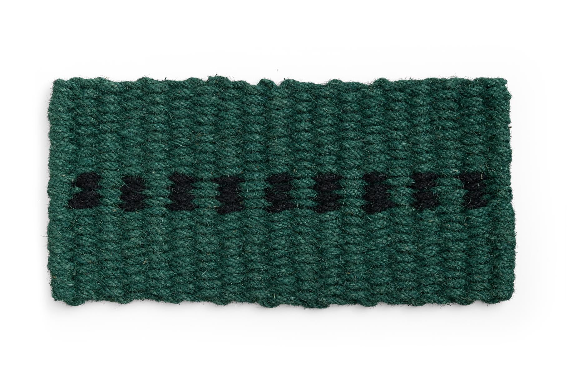 Green knitted door mat with black pattern on a white background