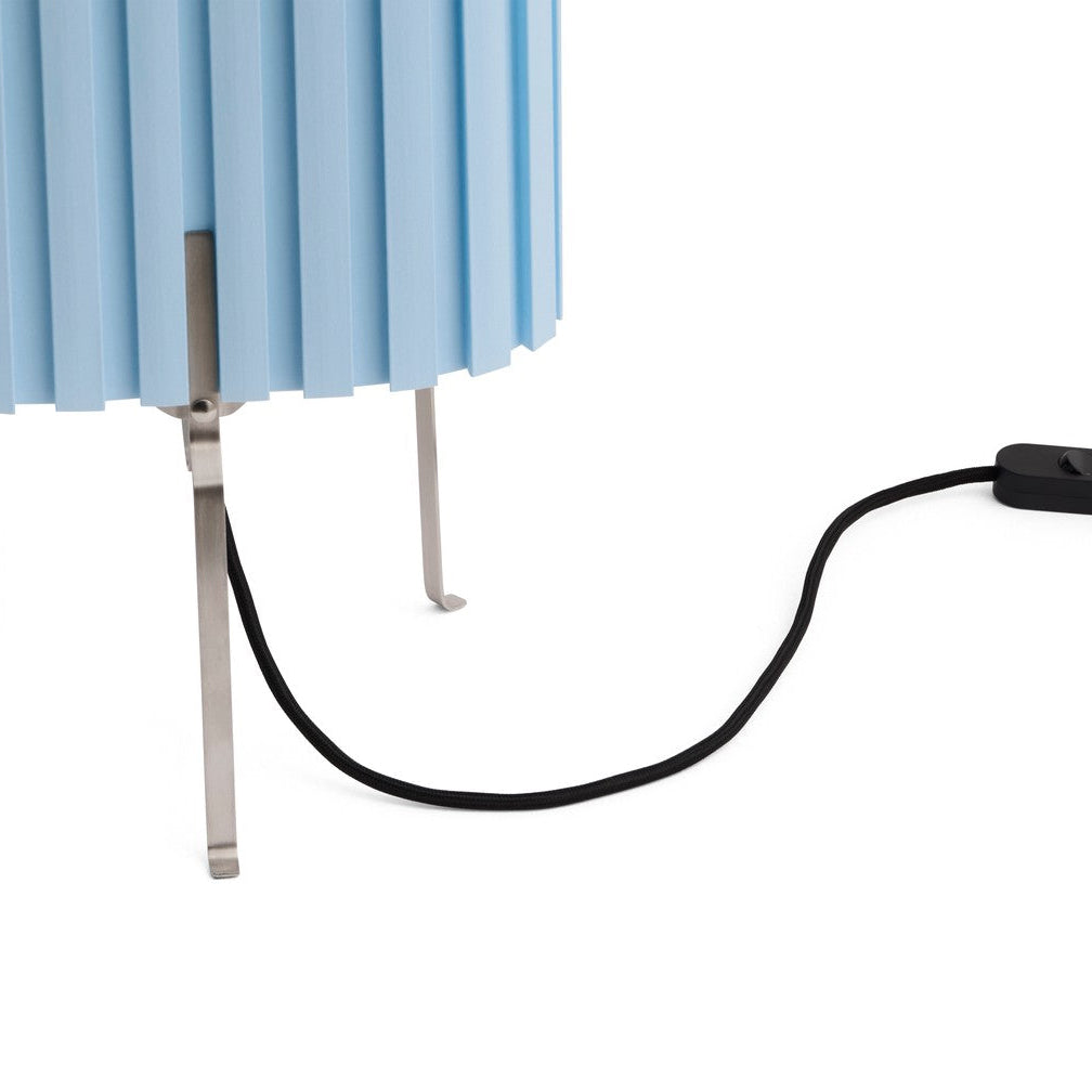Blue pleated lampshade with a black cord and switch on a white background