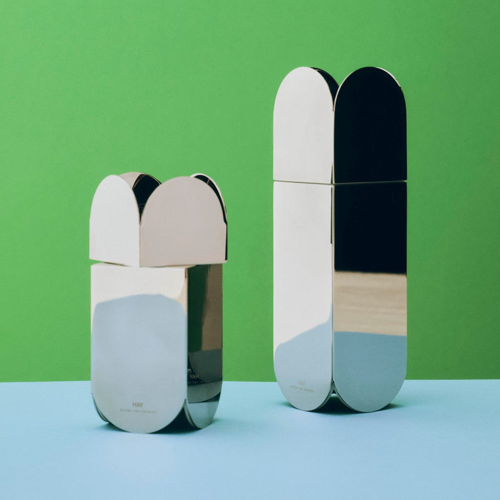 Two metallic containers with color-blocked design on a green and blue gradient background
