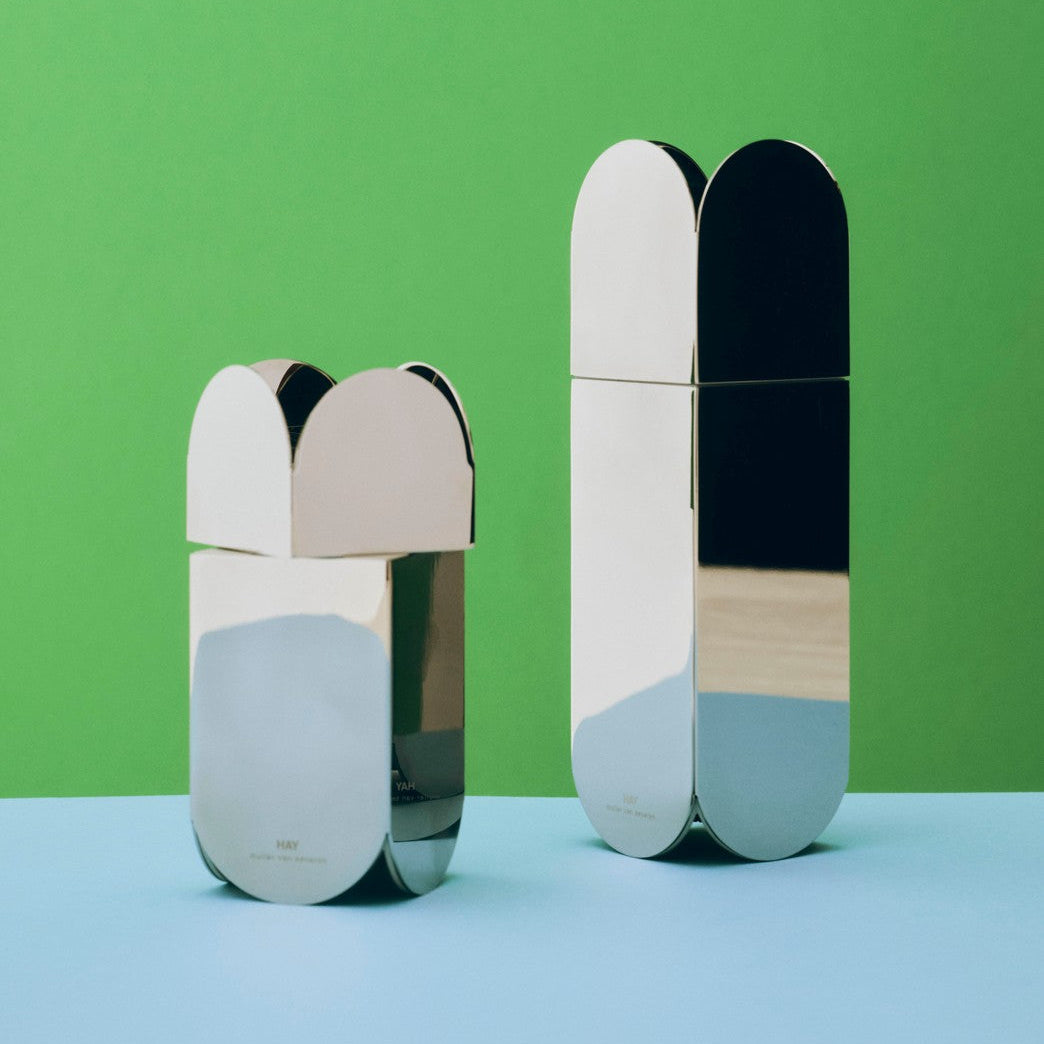 Two metallic containers with color-blocked design on a green and blue gradient background