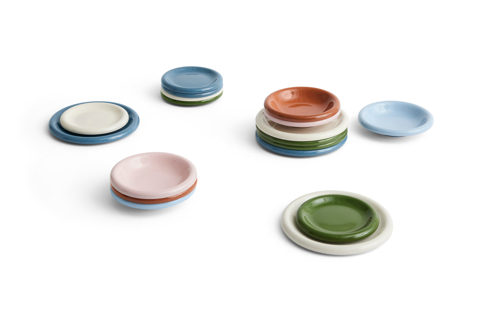Set of small ceramic plates in various colors on a white background