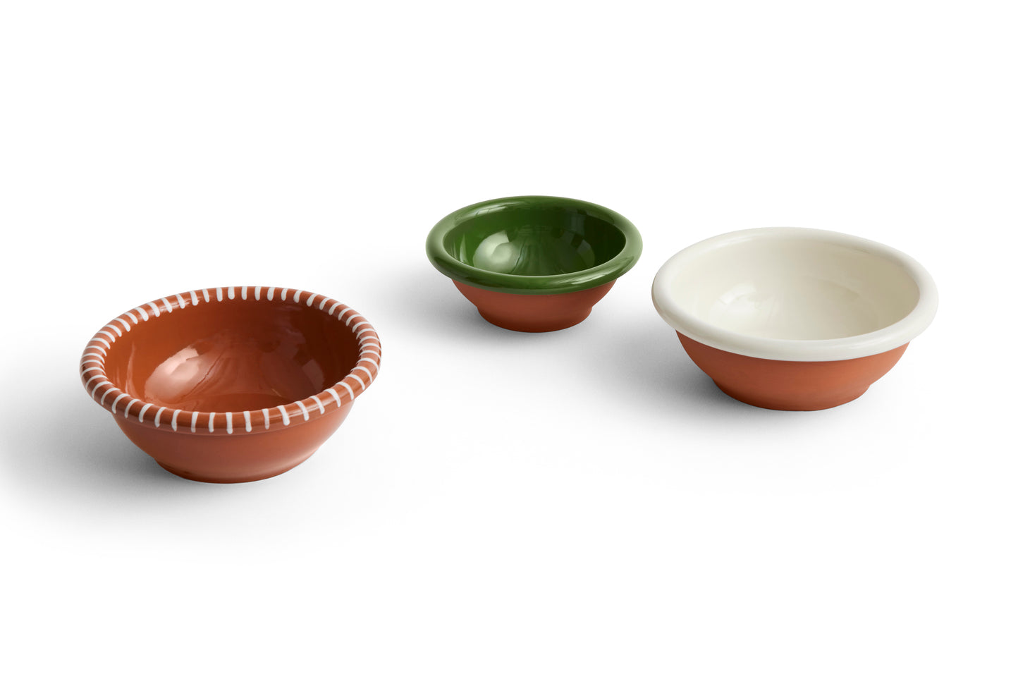 Three ceramic bowls in different colors on a white background
