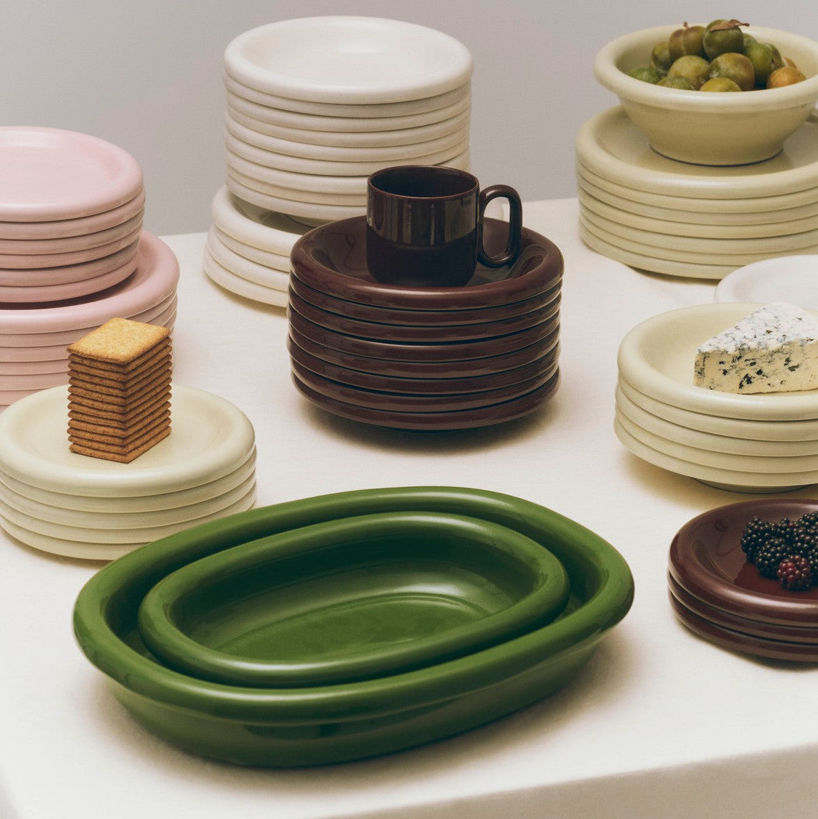 Collection of Rui Perera Baro ceramic dishes in various colours on a white surface.