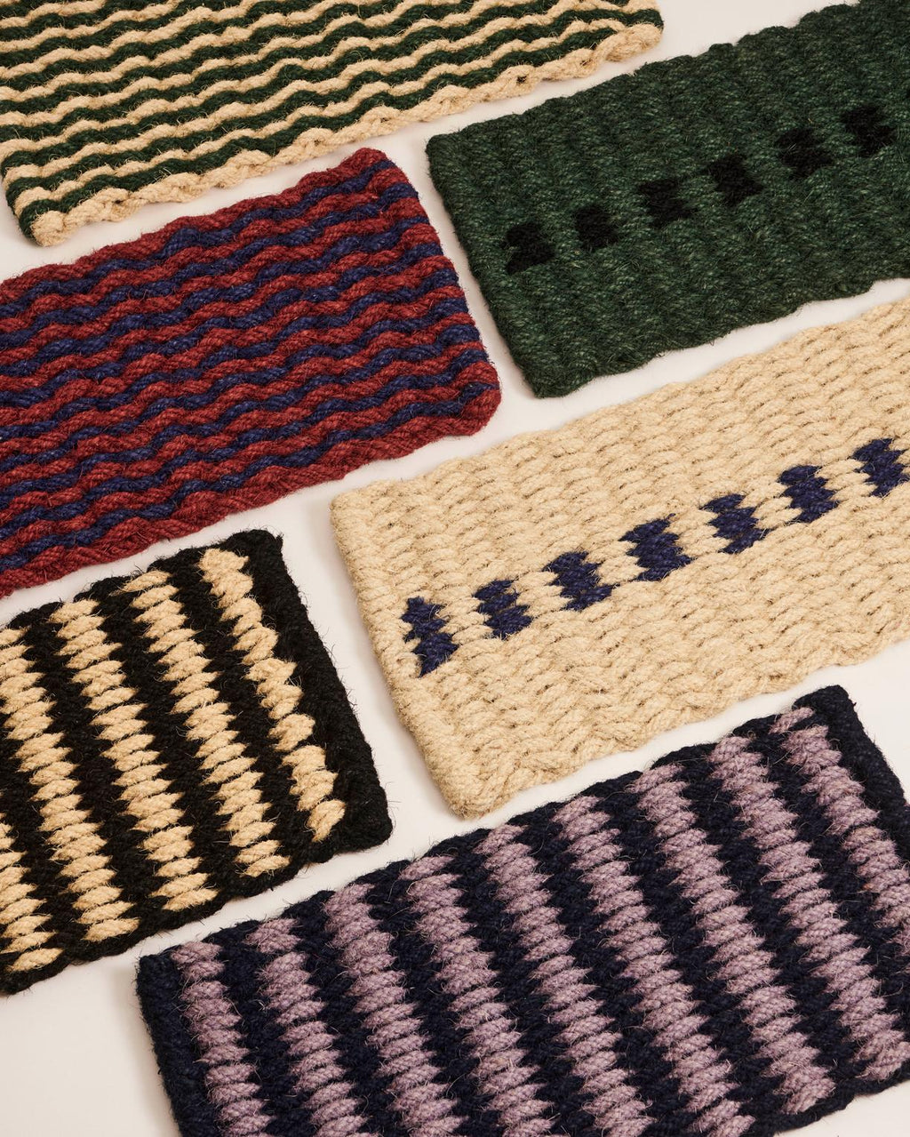 Collection of woven door mats with various patterns on a white background