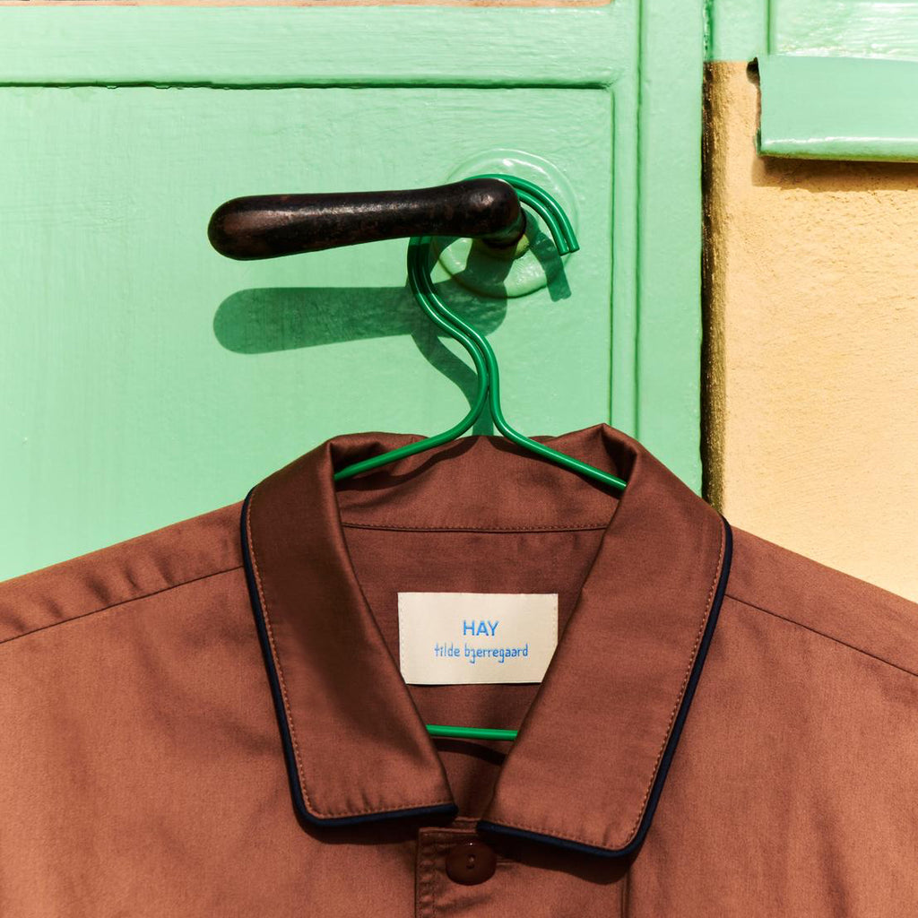 HAY Colour Hanger in Green with Brown PJ shirt hanging on green background