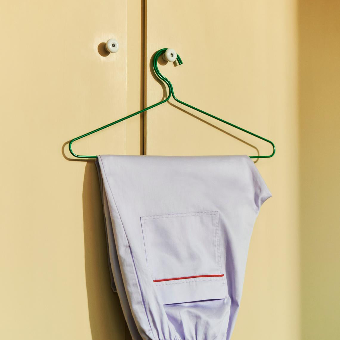 HAY Colour Hanger in Green with Brown PJ shirt hanging on green background